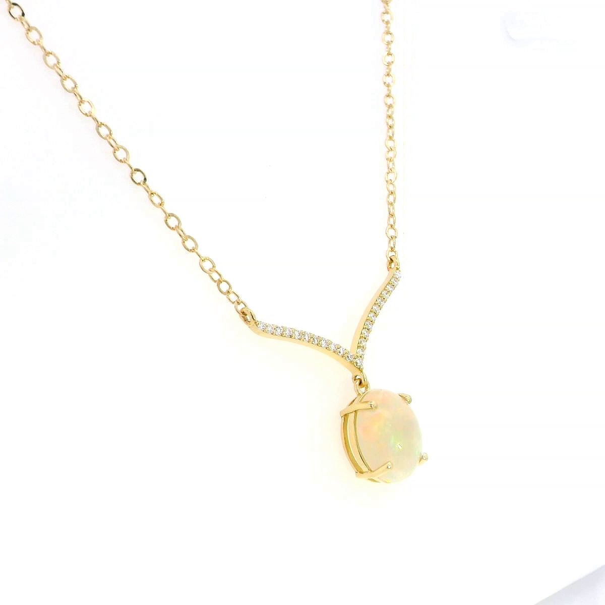 18K gold necklace with a 1.30-carat oval opal pendant, accented by a V-shaped row of pave-set diamonds totaling 0.10 carats, suspended on a delicate gold chain.
