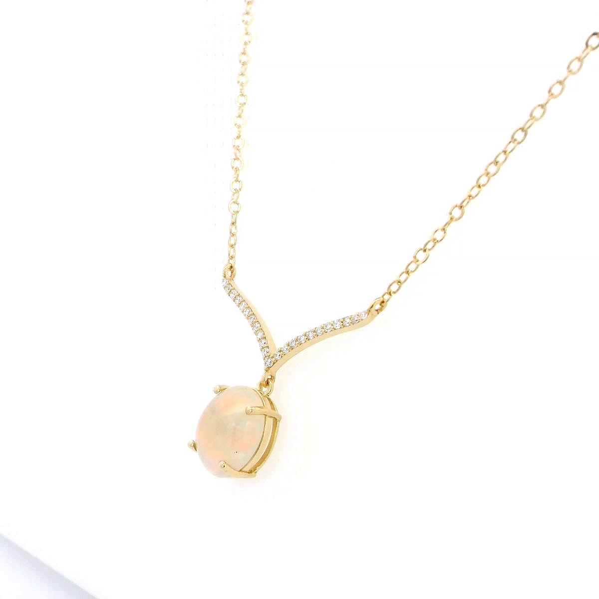 18K gold necklace with a 1.30-carat oval opal pendant, accented by a V-shaped row of pave-set diamonds totaling 0.10 carats, suspended on a delicate gold chain.