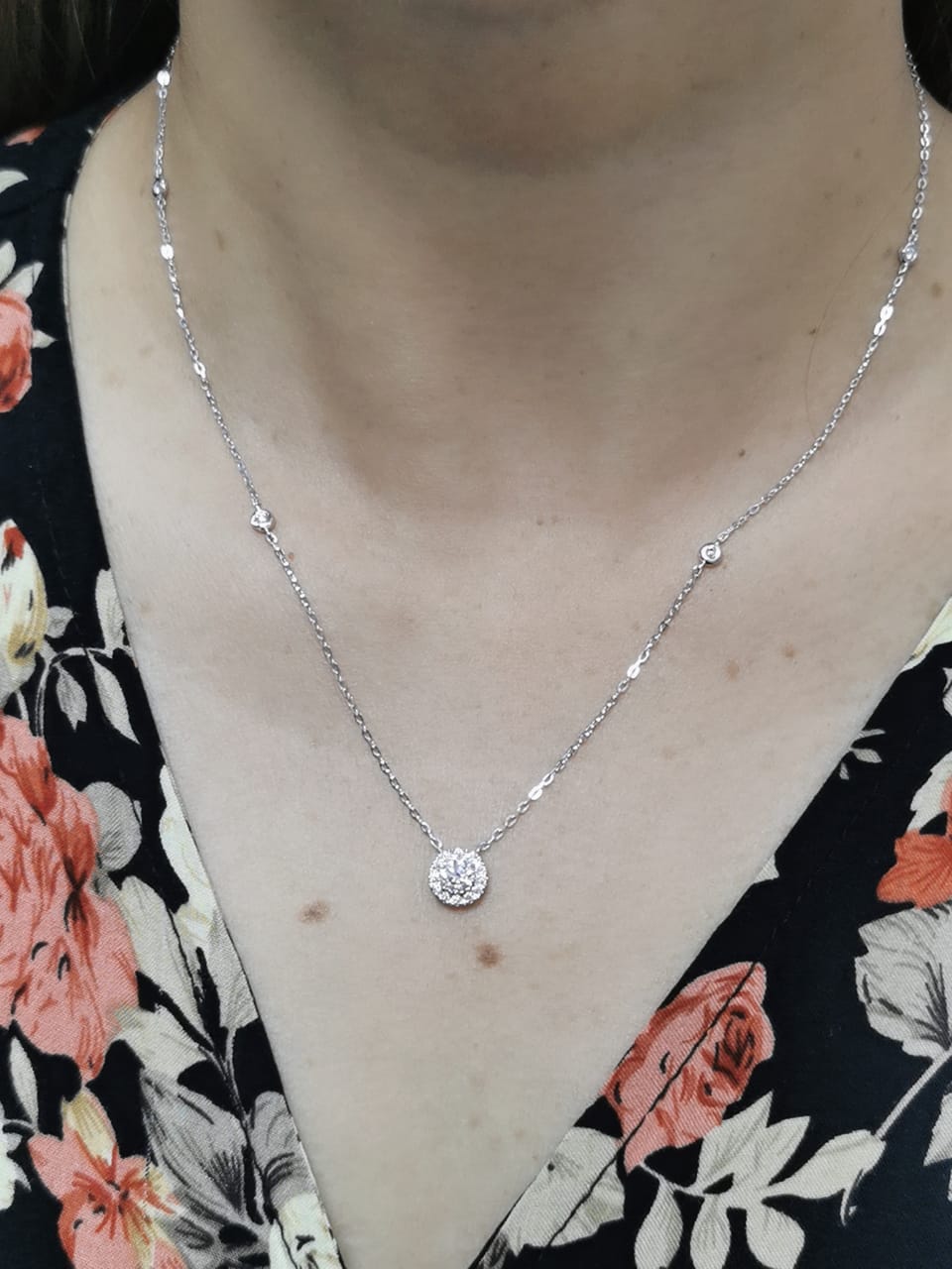 18K white gold diamond halo pendant necklace with 0.38ct round-cut center diamond and 0.21ct halo diamonds on white gold chain.