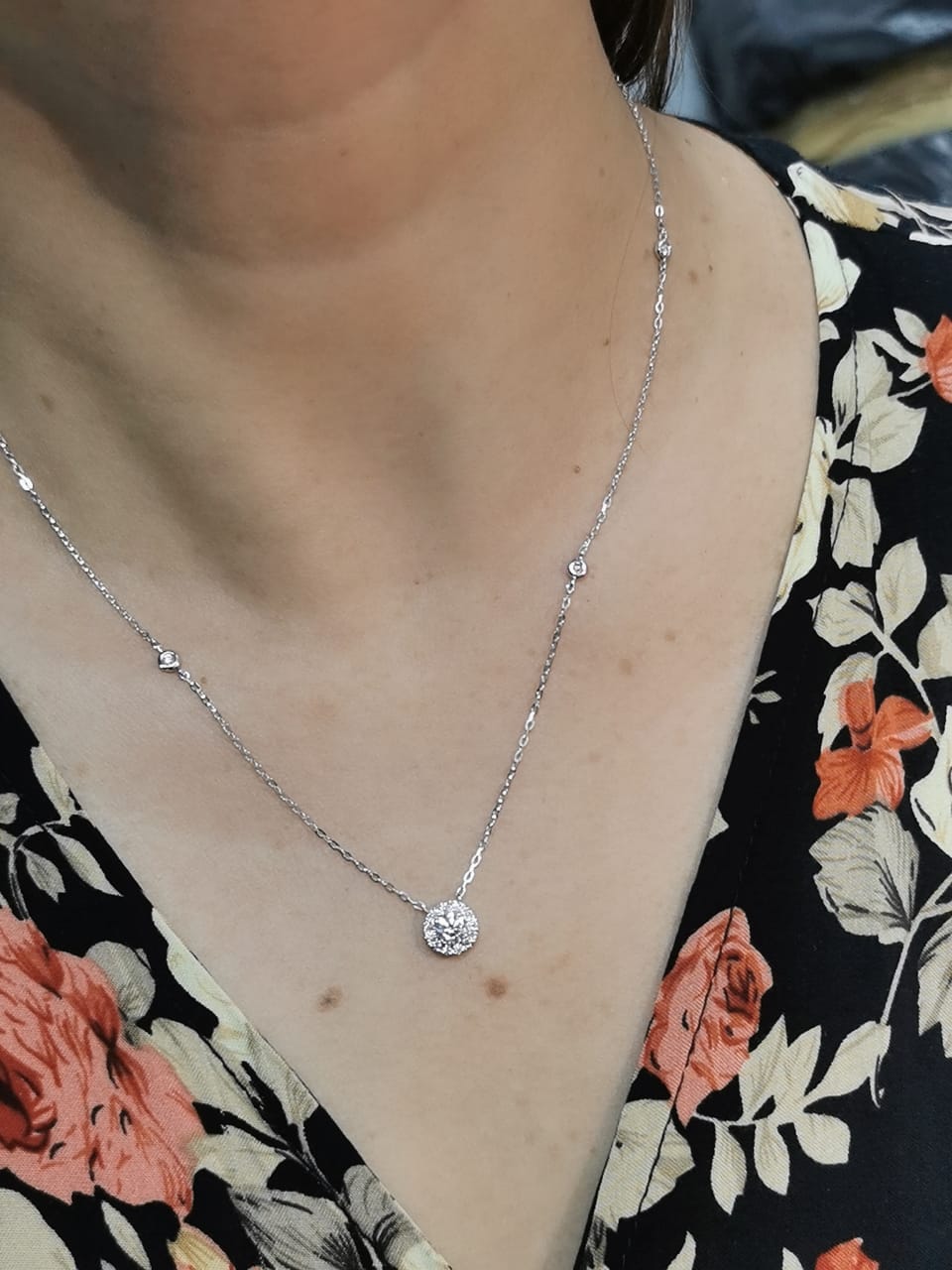 18K white gold diamond halo pendant necklace with 0.38ct round-cut center diamond and 0.21ct halo diamonds on white gold chain.