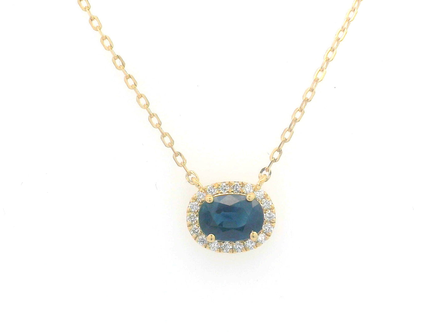 18K gold necklace featuring a 1.19-carat oval Blue Sapphire pendant, surrounded by a 0.14-carat diamond halo, suspended from a fine gold chain. Ideal for layering.