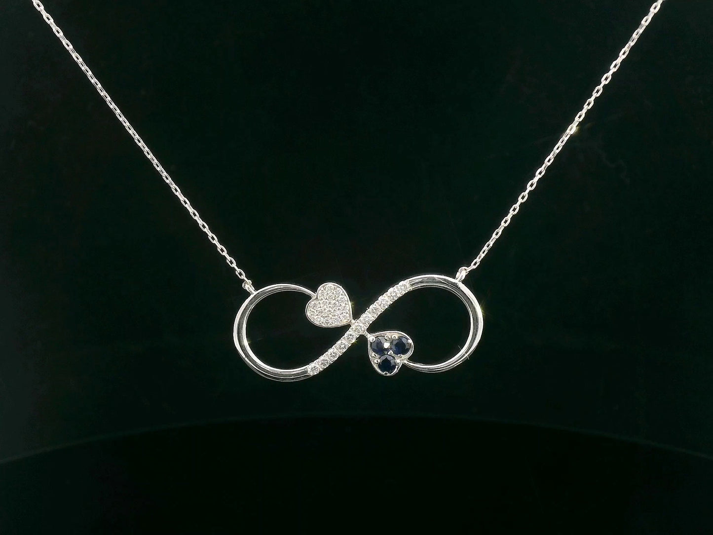 18K gold infinity necklace with heart-shaped diamond and sapphire accents, total 0.21 CT each