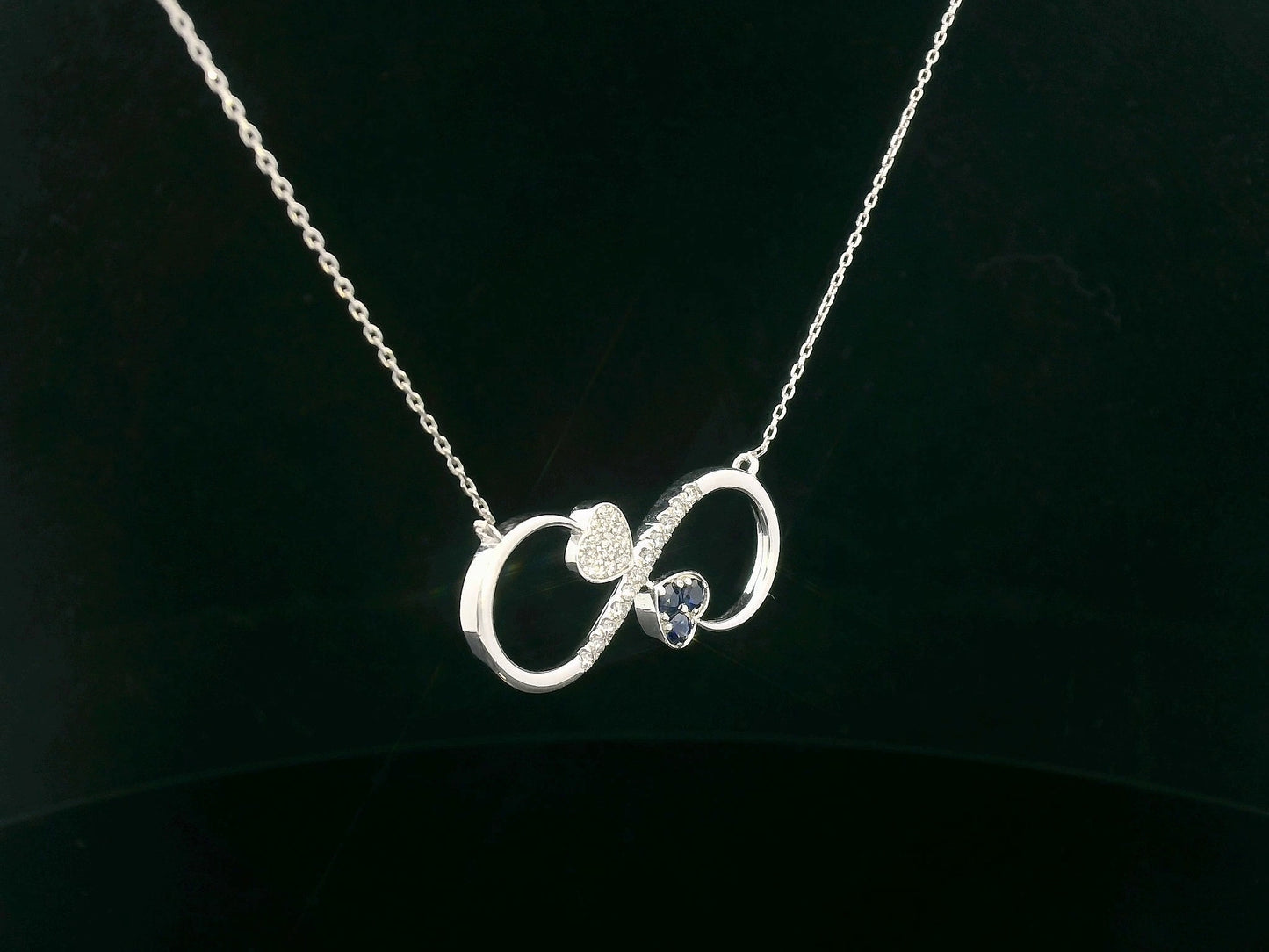 18K gold infinity necklace with heart-shaped diamond and sapphire accents, total 0.21 CT each