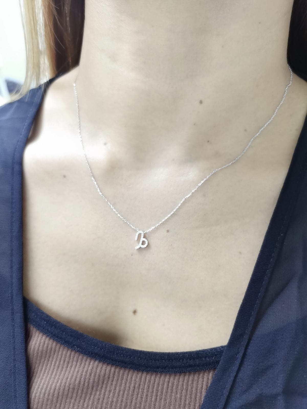 Capricorn zodiac necklace in 18K white gold with 0.08 carat diamond accents.