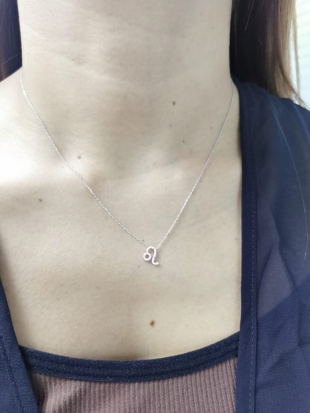 Leo zodiac sign necklace in 18K white gold with 0.08 carat diamond detailing.