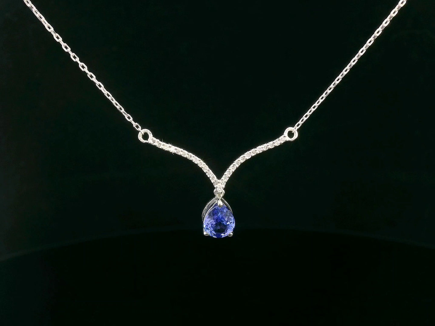 18K gold necklace with pear-shaped tanzanite drop and diamond-accented V-bar pendant