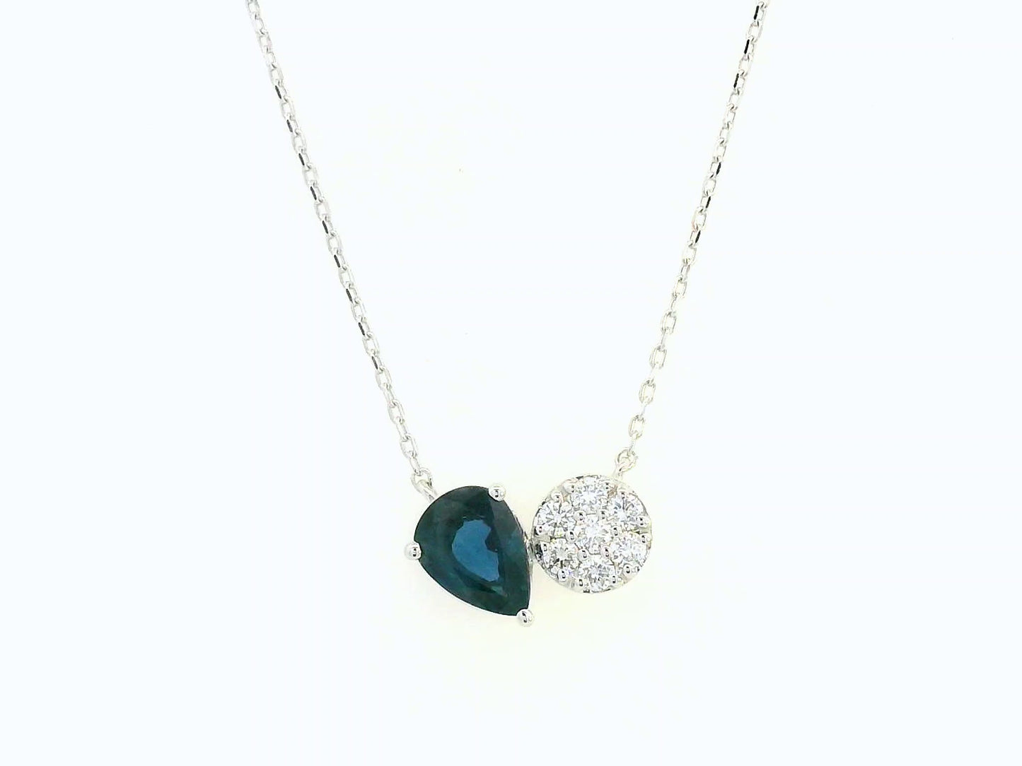 18K white gold pendant featuring a 0.97 carat pear-cut blue sapphire and 0.17 carat round diamond cluster on a fine gold chain.
