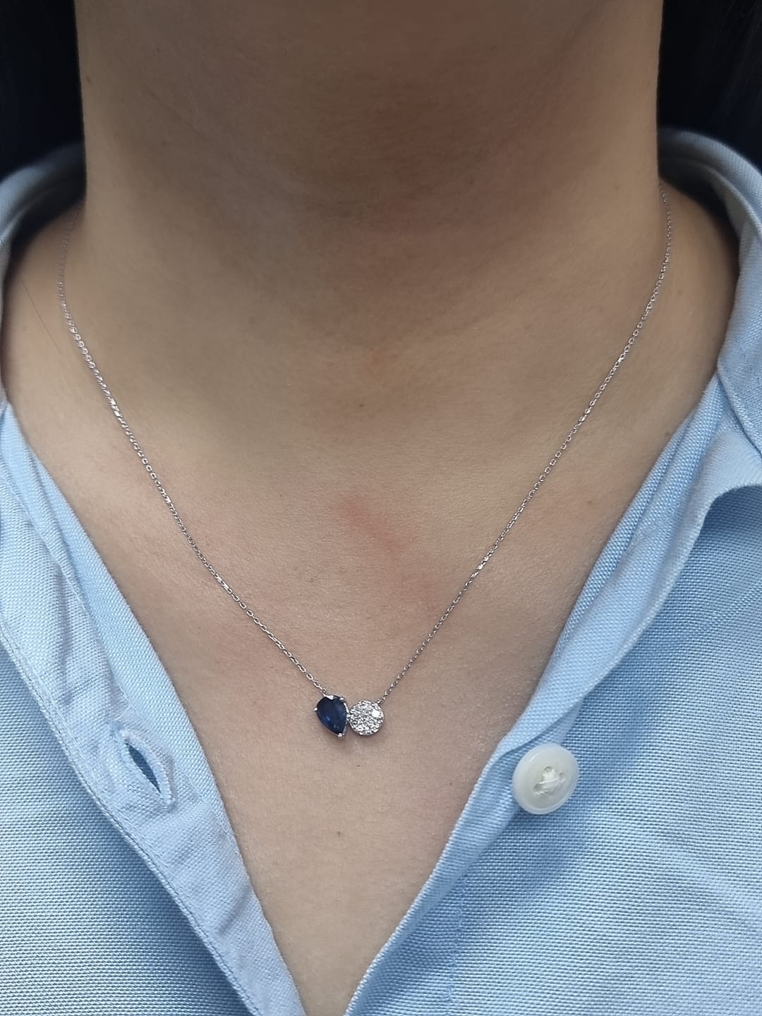 18K white gold pendant featuring a 0.97 carat pear-cut blue sapphire and 0.17 carat round diamond cluster on a fine gold chain.