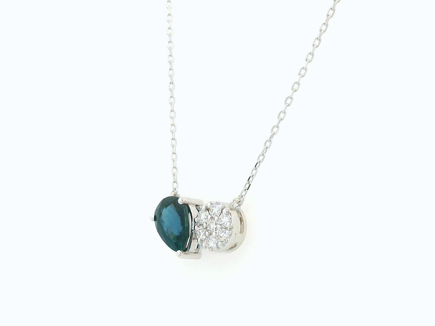 18K white gold pendant featuring a 0.97 carat pear-cut blue sapphire and 0.17 carat round diamond cluster on a fine gold chain.