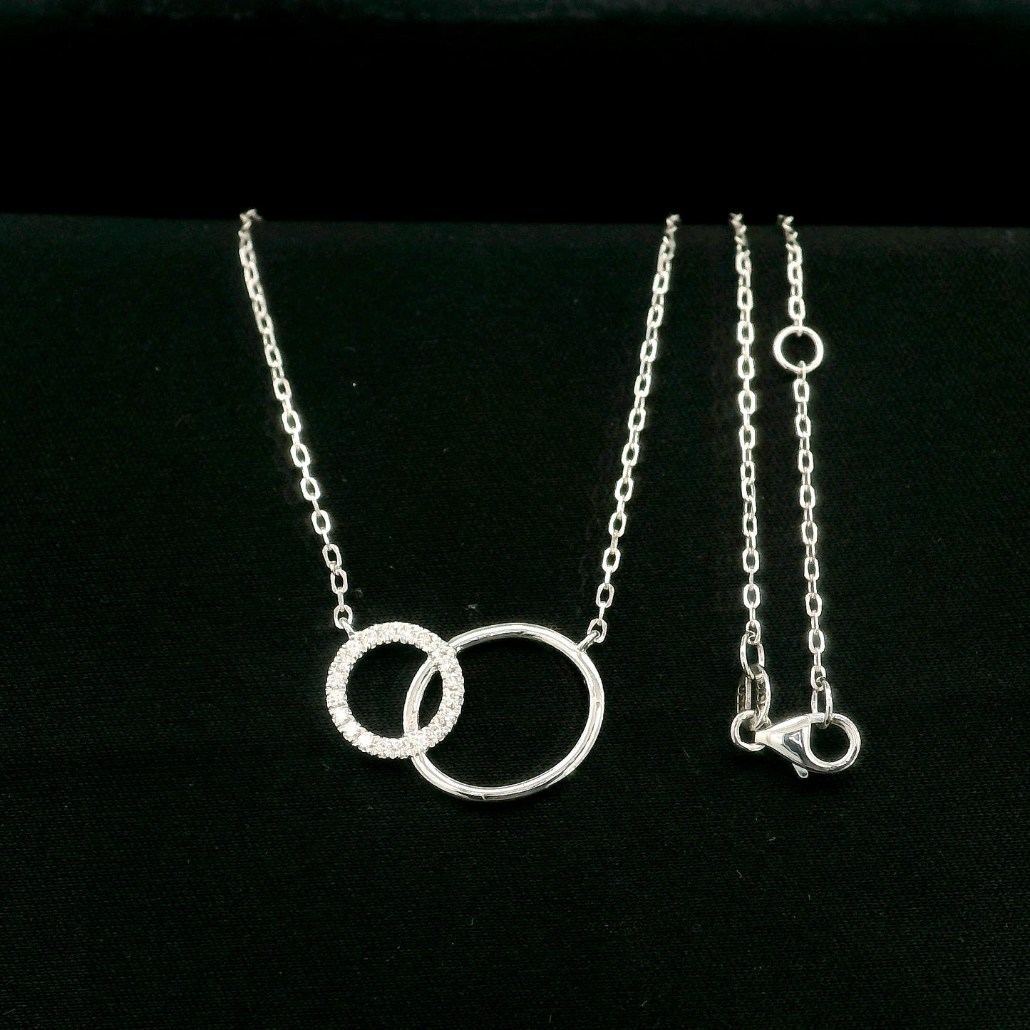 Interlocking circle diamond necklace in 18K white gold with one pavé diamond circle and one polished circle.