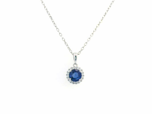 "18K white gold sapphire and diamond halo pendant featuring a 0.72ct deep blue sapphire surrounded by a 0.10ct diamond halo,