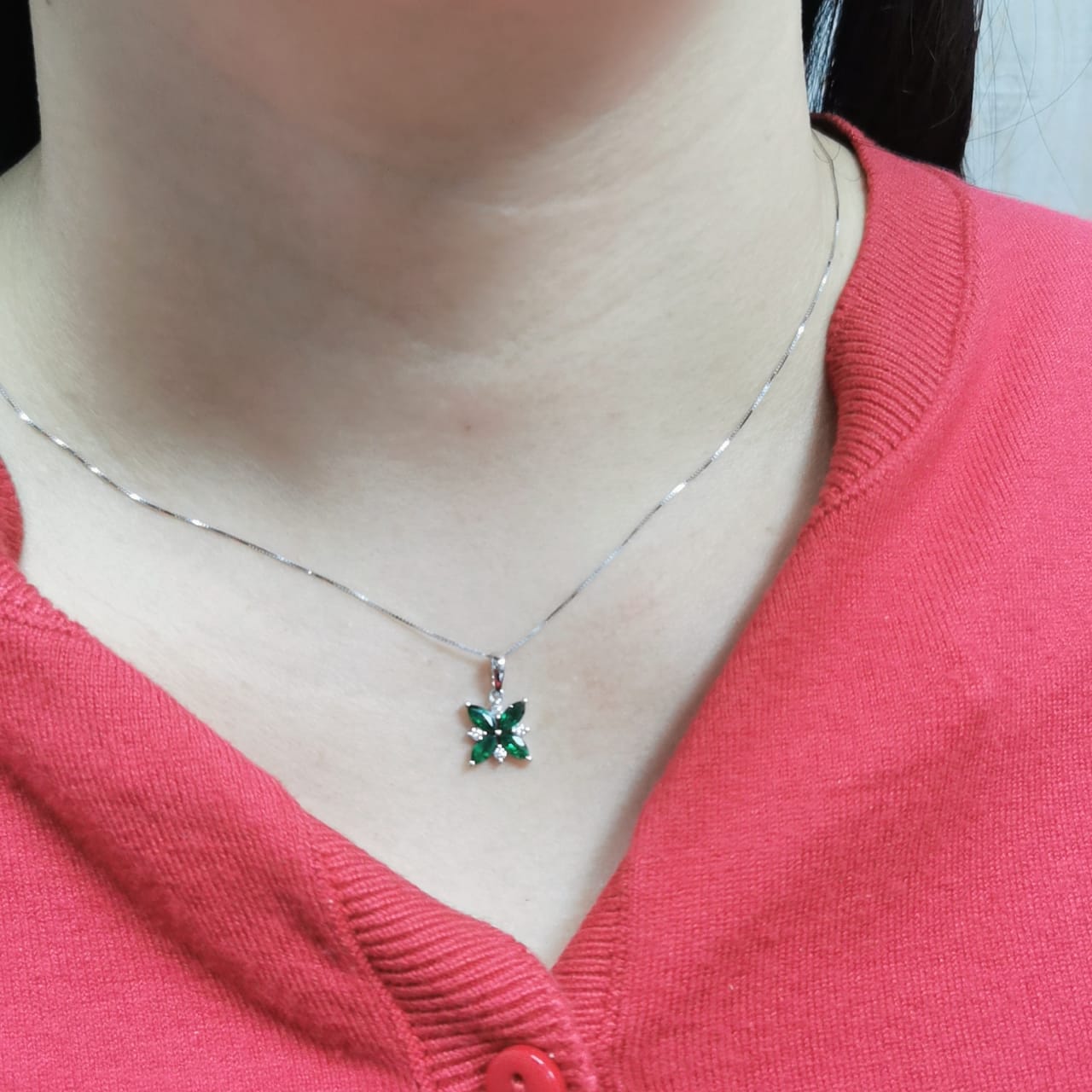 18K gold floral pendant featuring 0.57 CT natural emeralds and 0.07 CT diamonds, designed in a delicate flower shape.