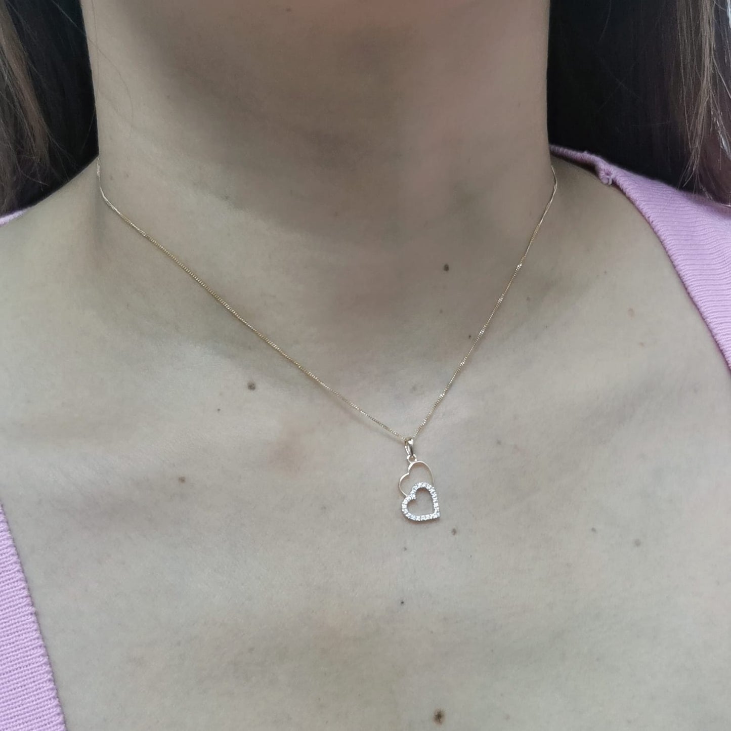 18K gold double-heart pendant with 0.10ct diamonds. Chain not included.
