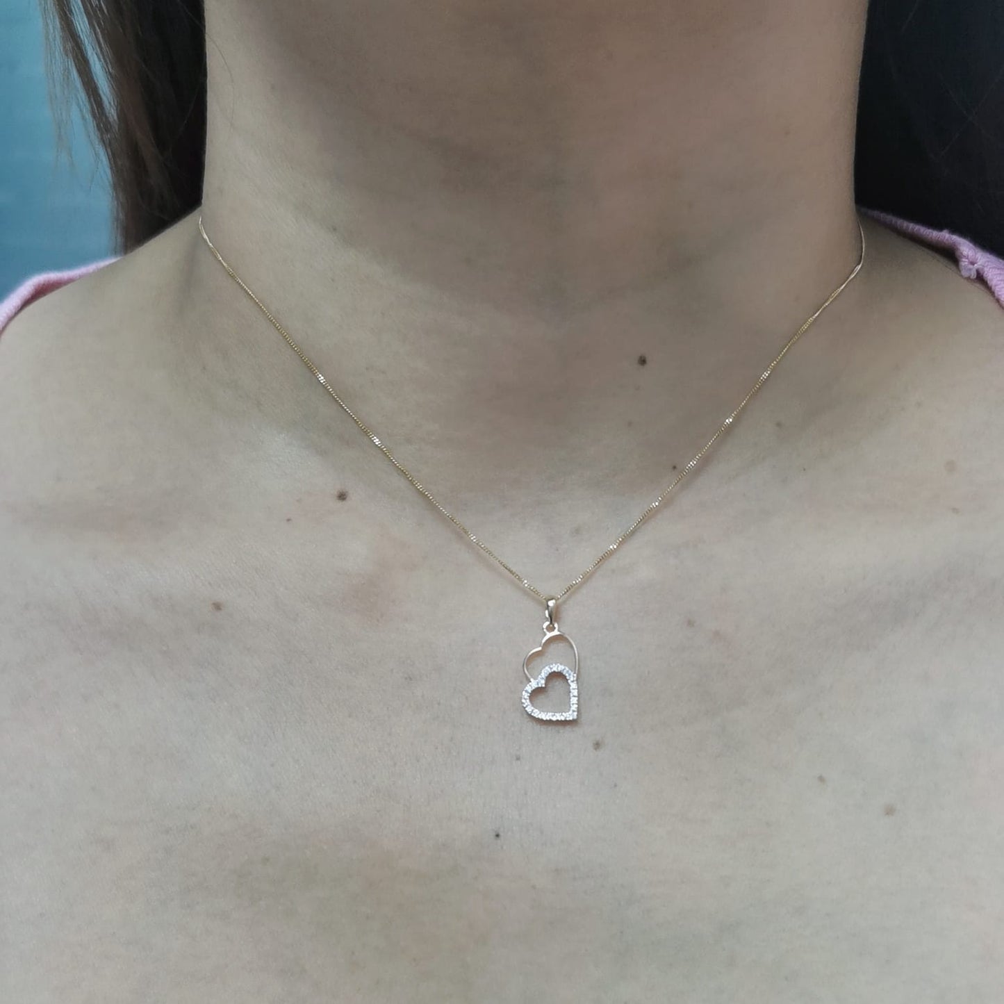 18K gold double-heart pendant with 0.10ct diamonds. Chain not included.