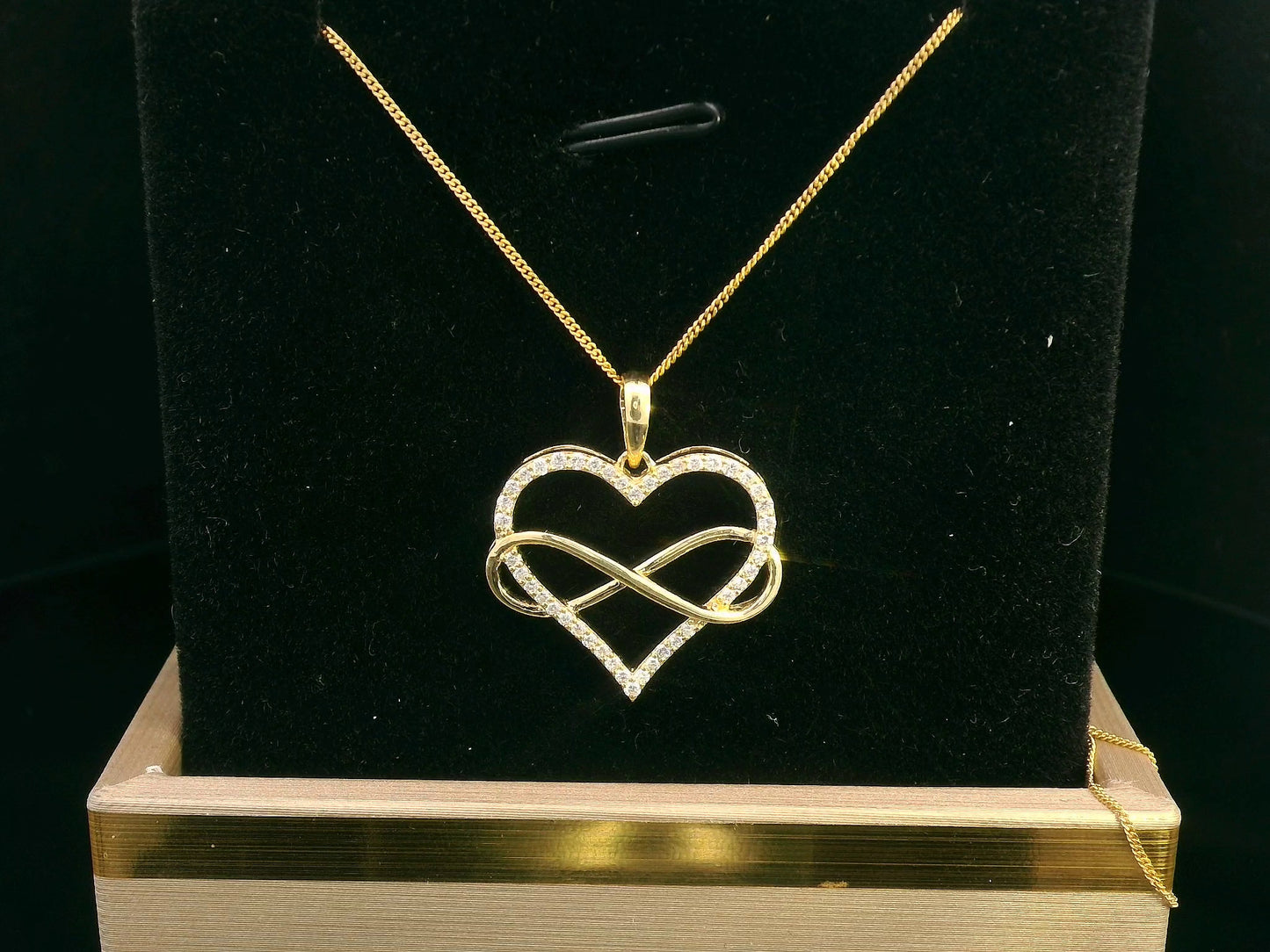 18K gold heart and infinity pendant with 0.22ct pave-set diamonds, symbolizing eternal love. Chain not included.