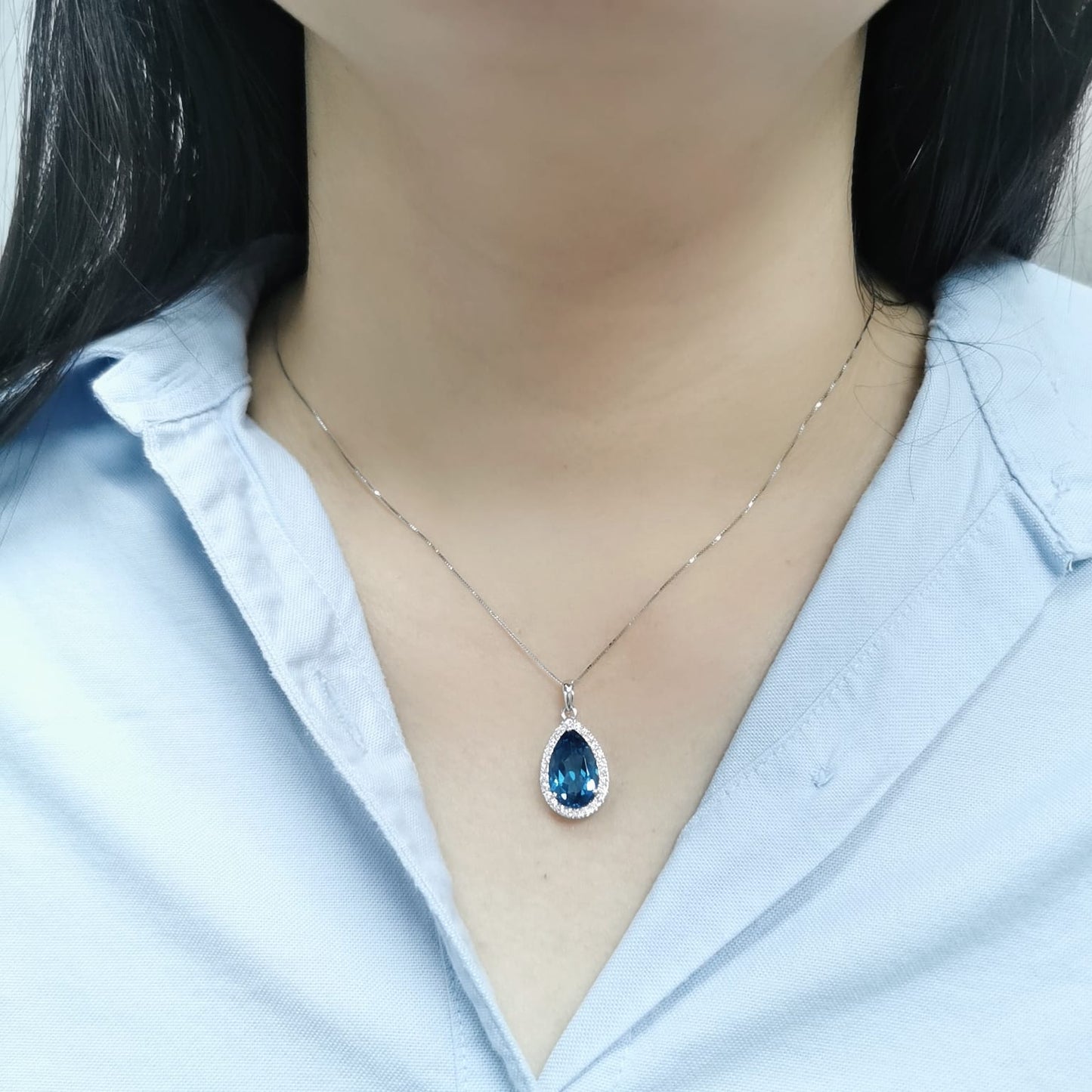18K white gold pendant with a 5.87ct pear-shaped London Blue Topaz, surrounded by a 0.33ct diamond halo. Chain not included.