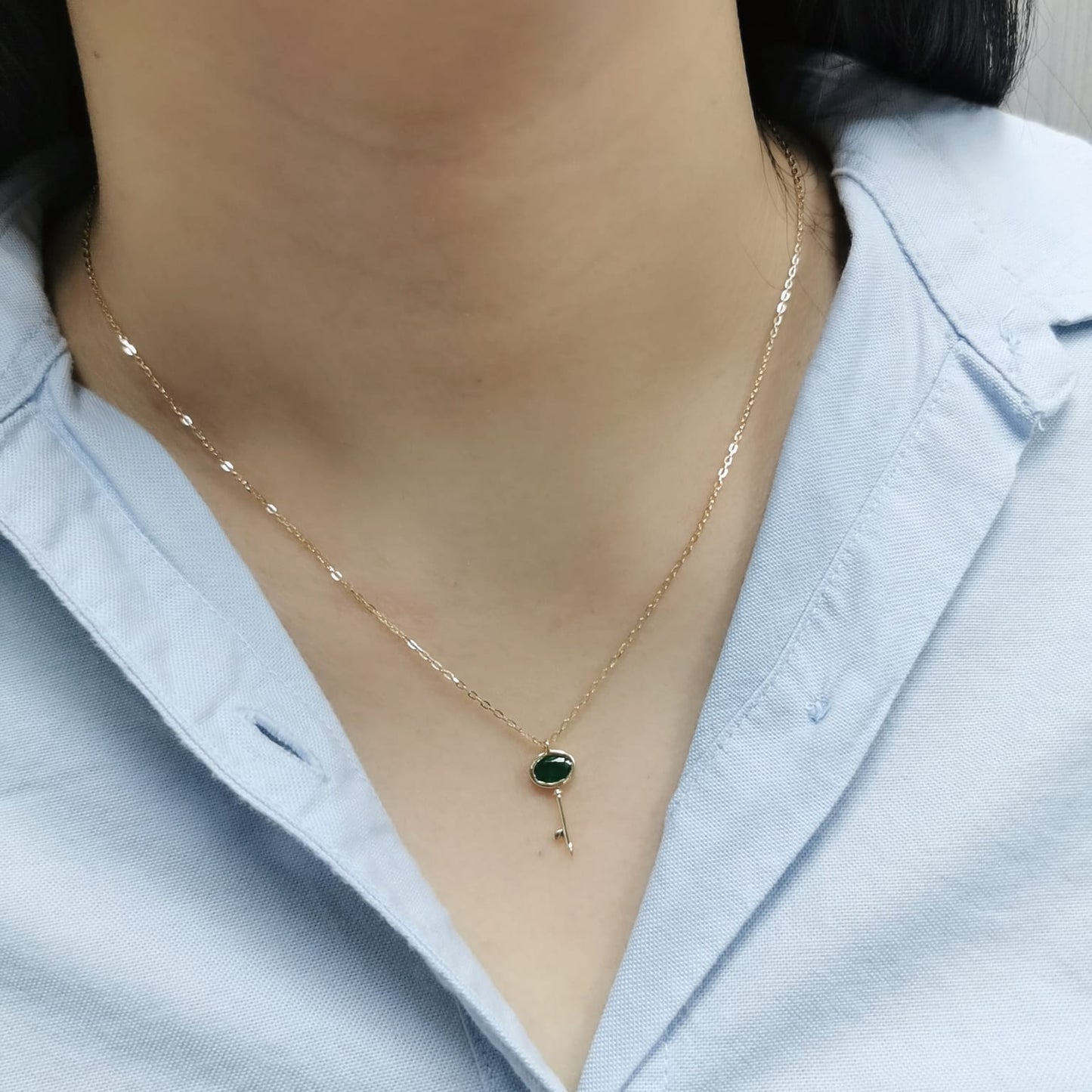 18K gold key pendant necklace with a 0.39ct natural emerald, featuring a sleek bezel setting and a delicate gold chain.
