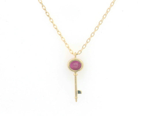18K gold key pendant necklace with a 0.39ct natural ruby, featuring a sleek bezel setting and a delicate gold chain.