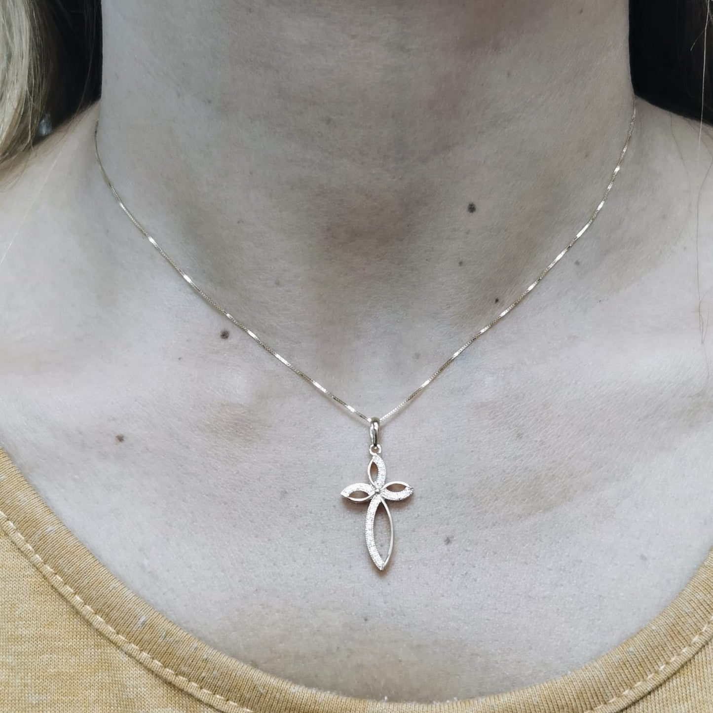 Elegant 18K gold cross pendant with pavé-set diamonds, featuring marquise-shaped curves and 0.10 carat diamond accents.