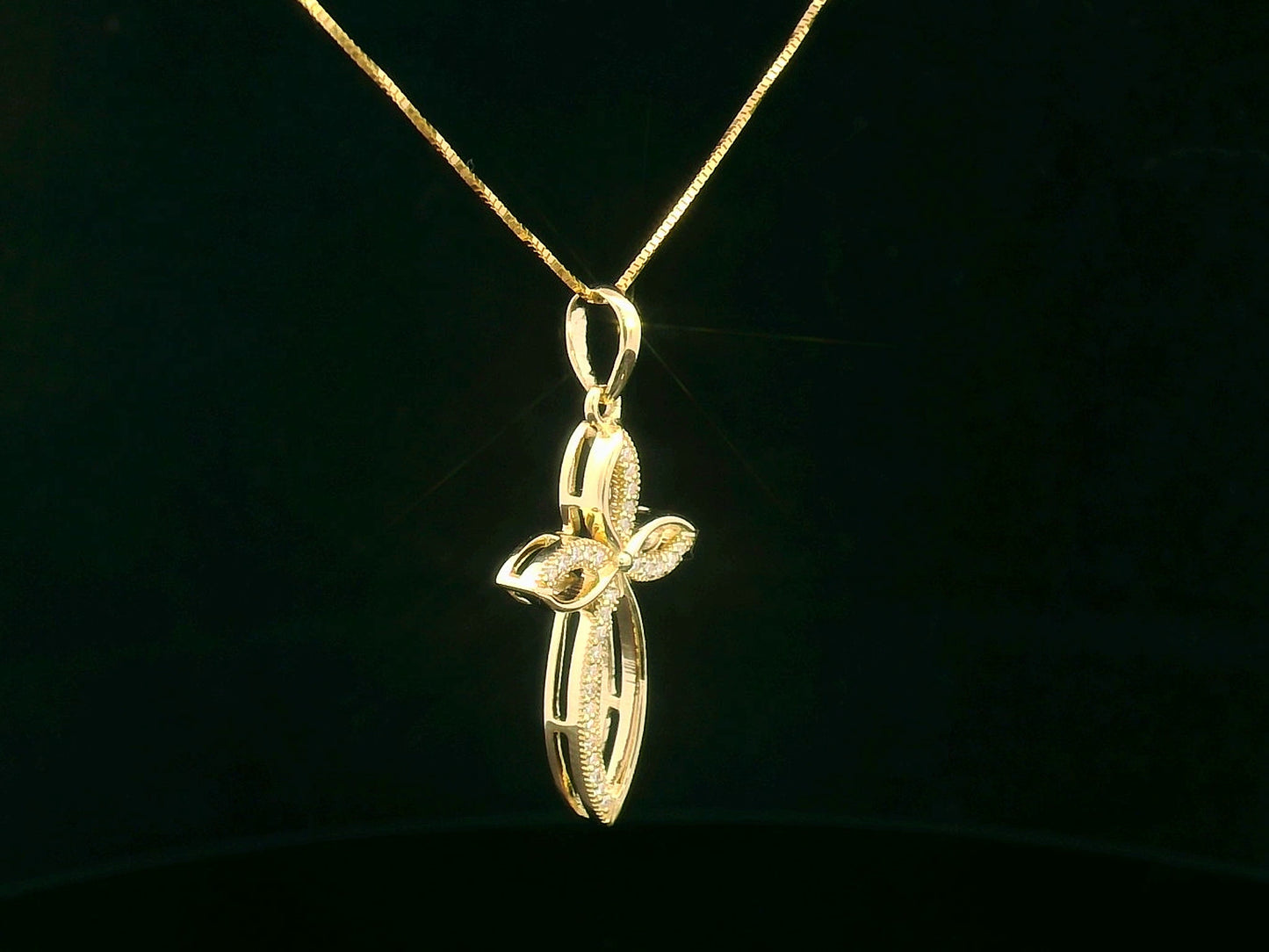 Elegant 18K gold cross pendant with pavé-set diamonds, featuring marquise-shaped curves and 0.10 carat diamond accents.