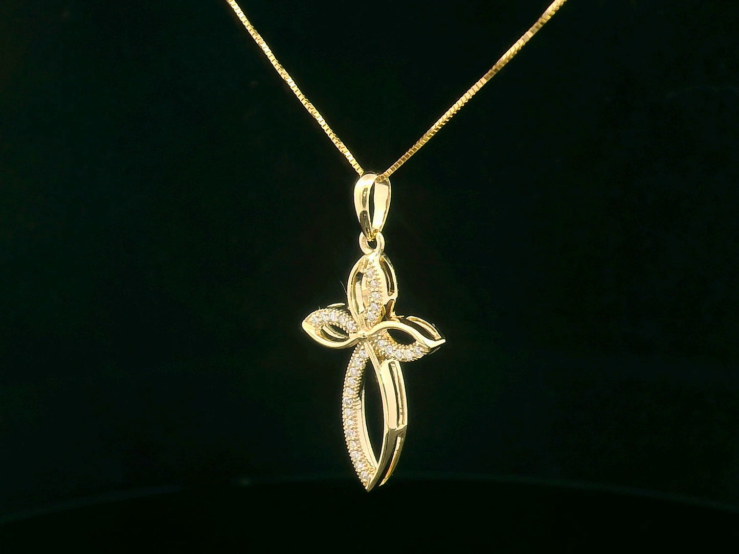 Elegant 18K gold cross pendant with pavé-set diamonds, featuring marquise-shaped curves and 0.10 carat diamond accents.