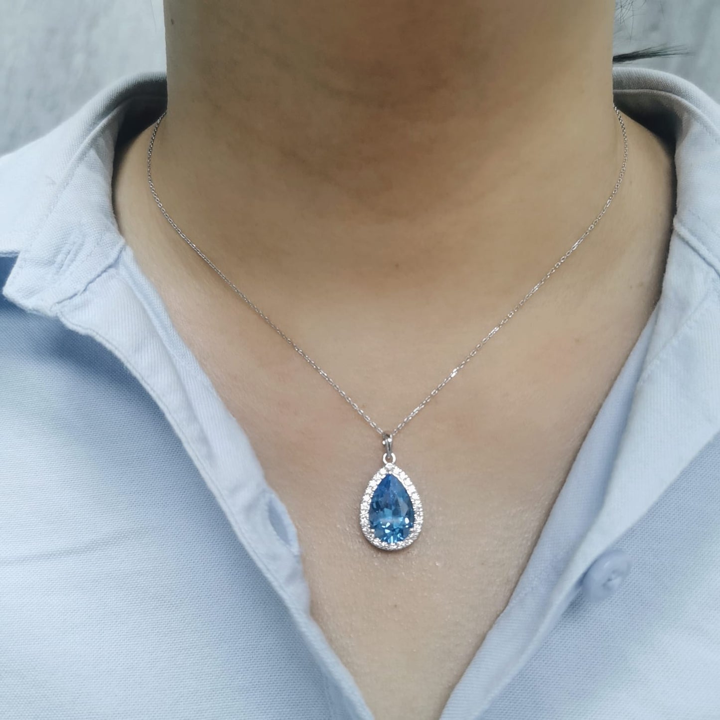 Elegant pear-cut topaz pendant with diamond border in white gold