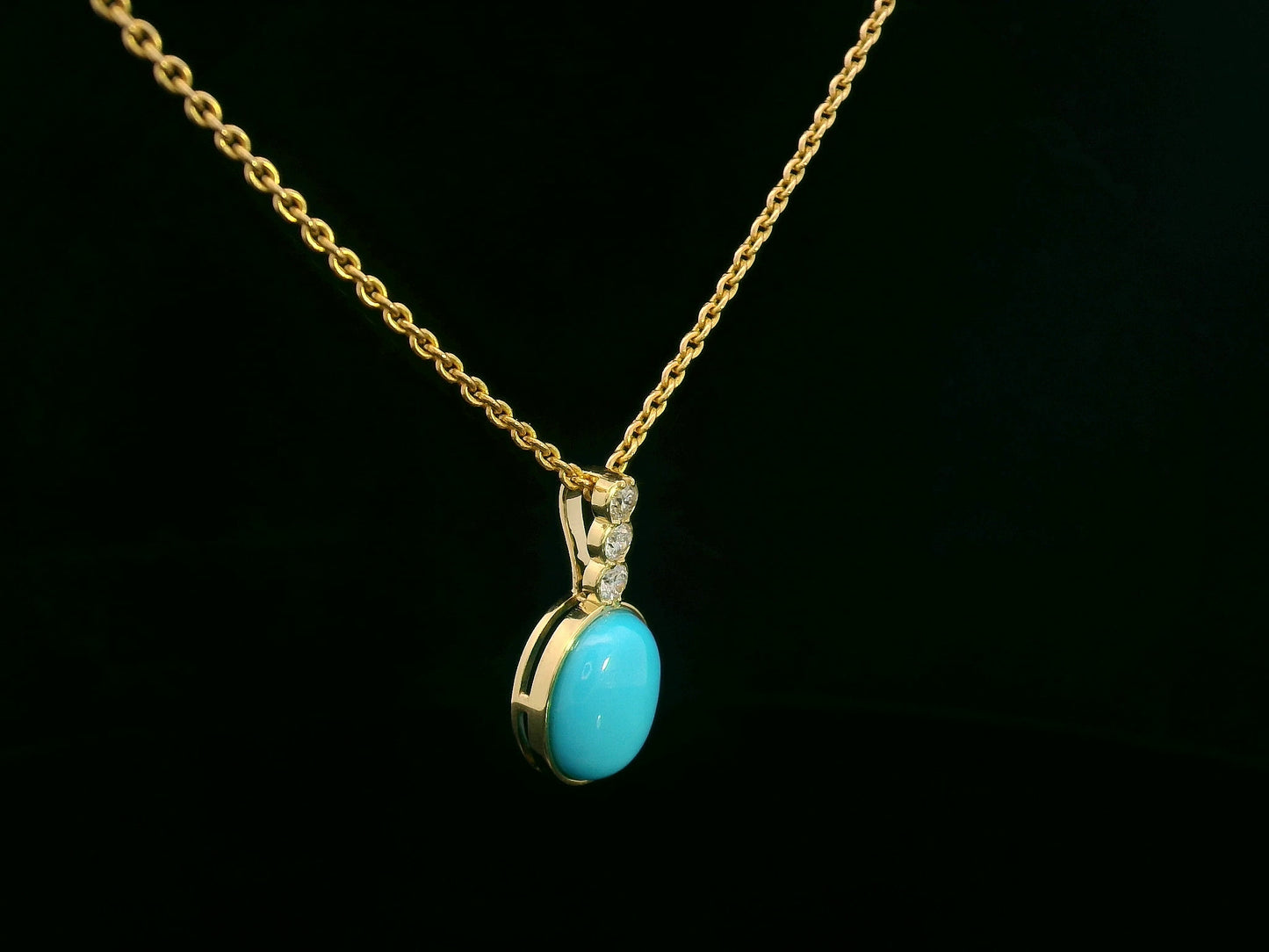 18K yellow gold pendant with 2.46ct oval turquoise and 0.14ct diamond accents.