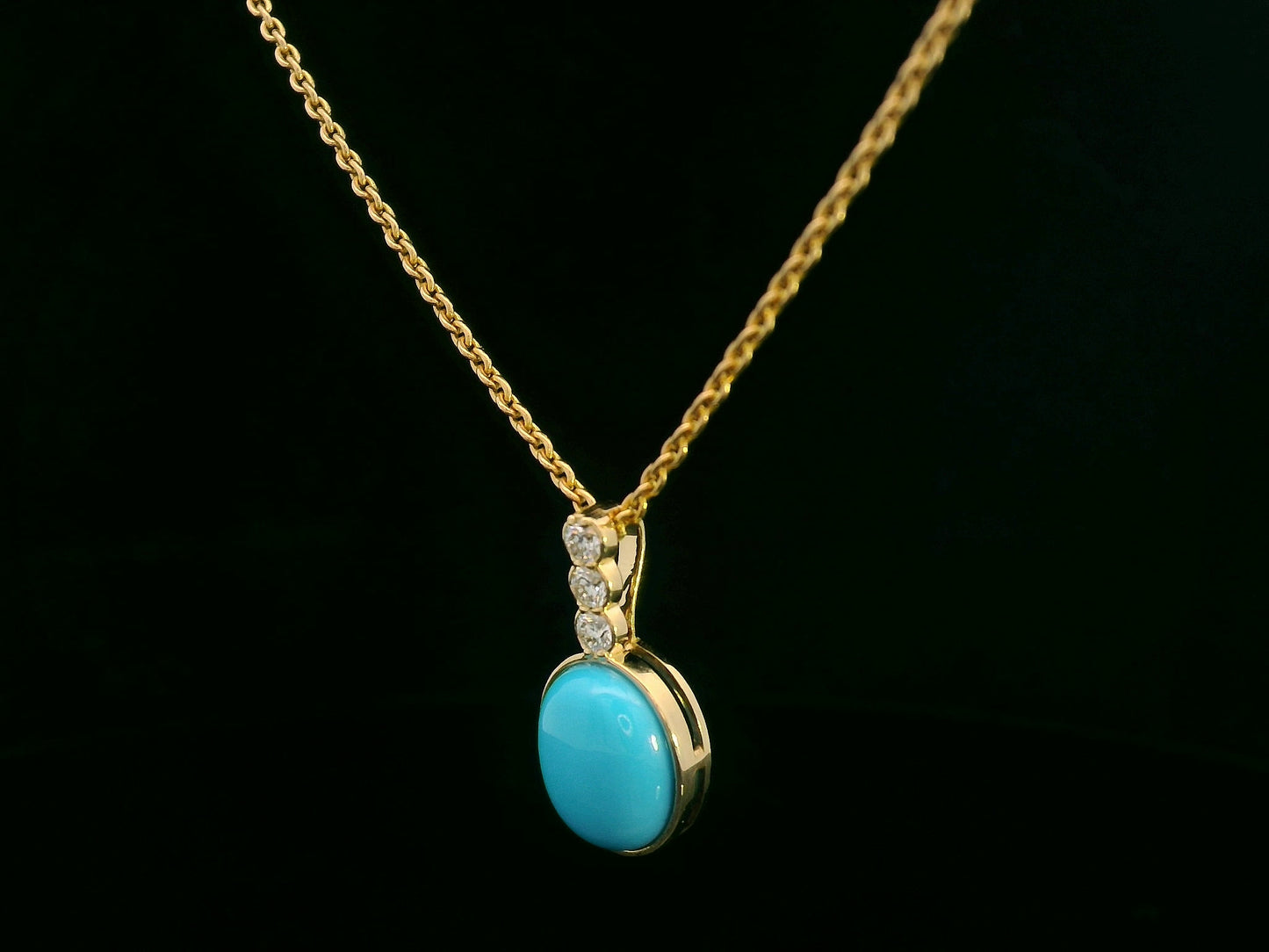 18K yellow gold pendant with 2.46ct oval turquoise and 0.14ct diamond accents.