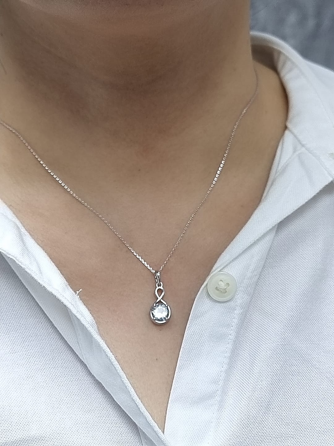 18k white gold pendant with 1.10-carat round-cut aquamarine in infinity-style bail design