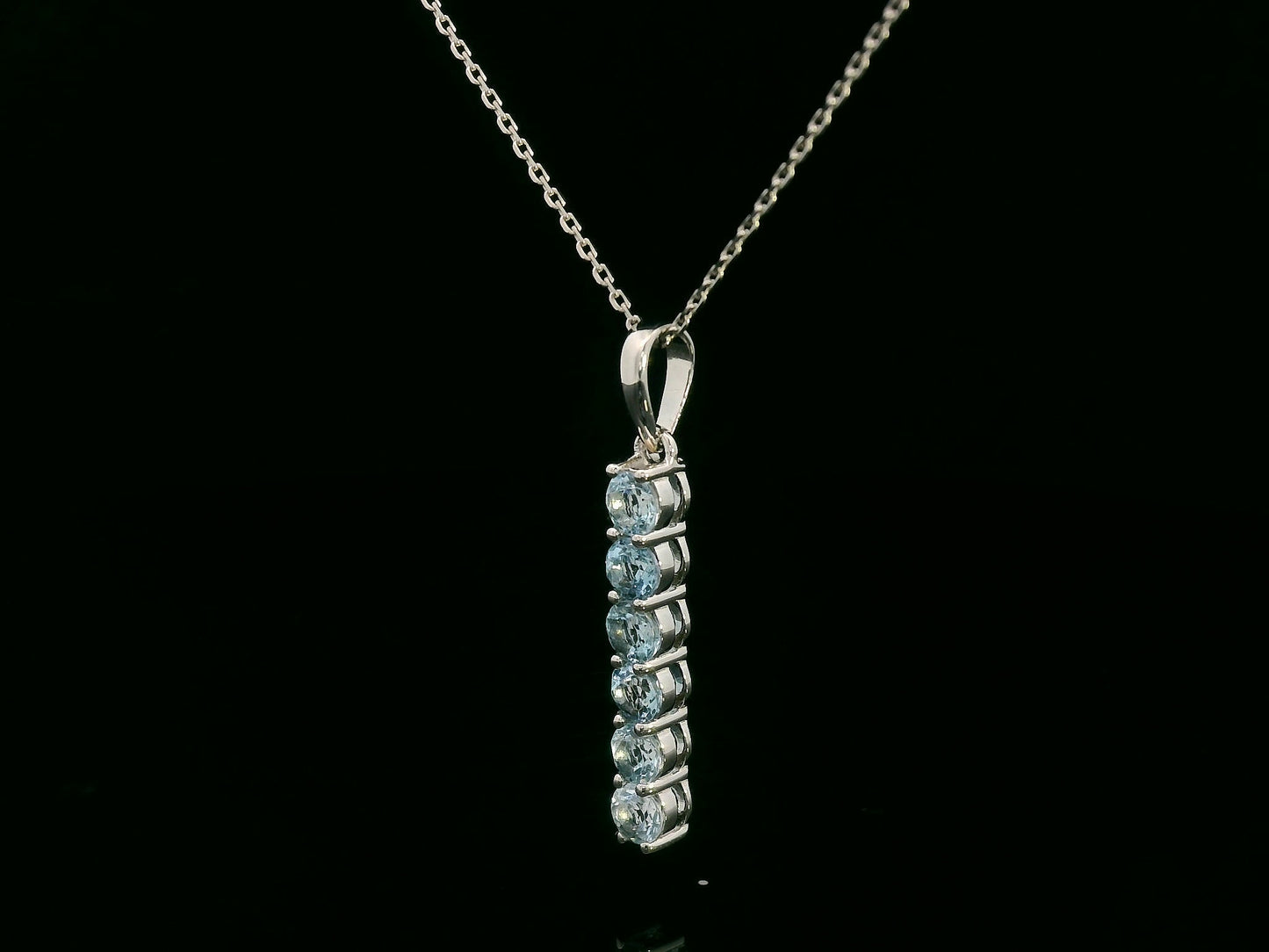 18k gold vertical bar pendant with six round-cut aquamarines totaling 0.72 carat