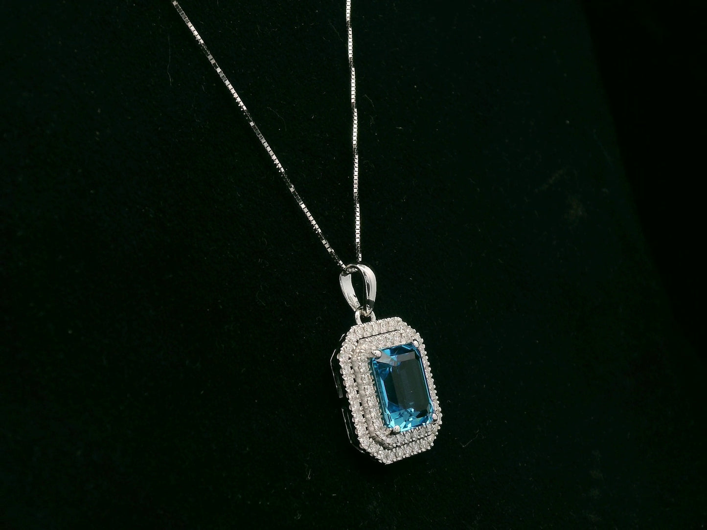 18K white gold Swiss blue topaz and diamond halo pendant with emerald-cut center stone – Emirates Diamonds