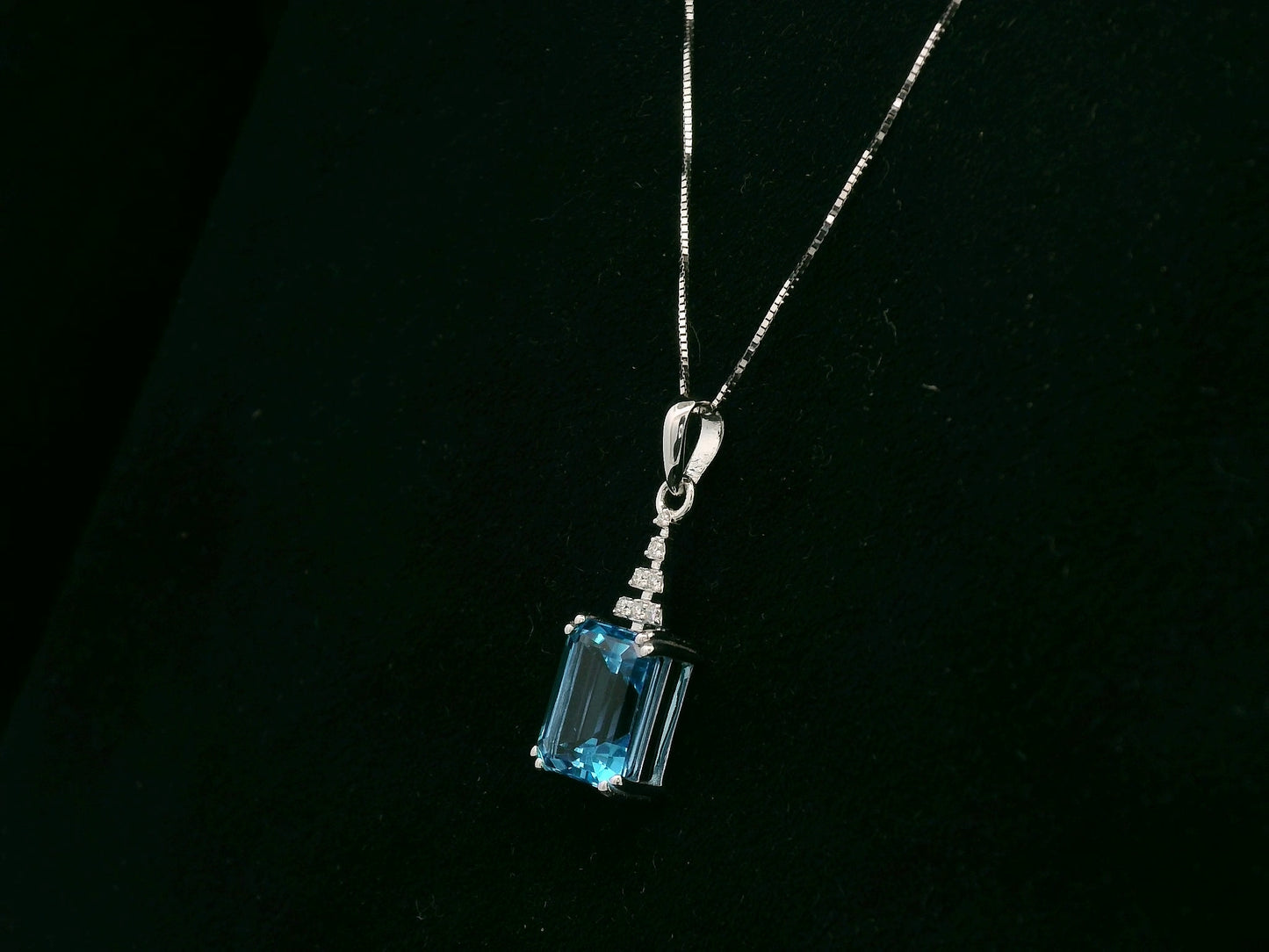 18K white gold Swiss Blue Topaz pendant with emerald-cut blue gemstone and diamond accents by Emirates Diamonds.