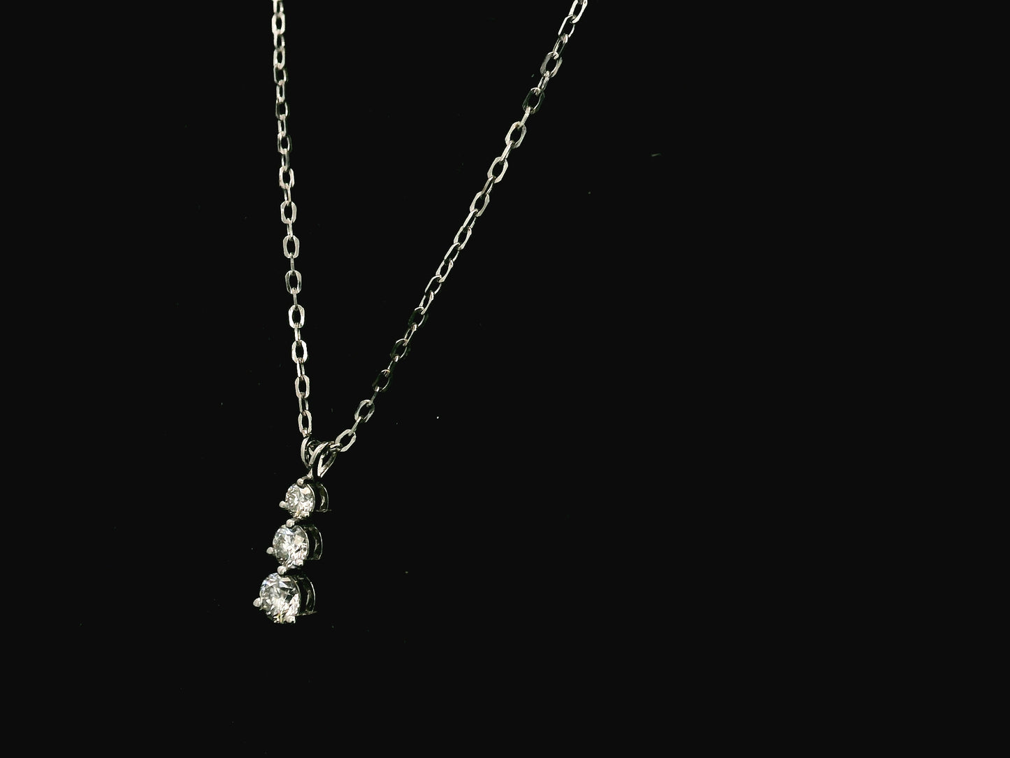 18K white gold three stone natural diamond journey pendant necklace featuring 0.36 carat round brilliant diamonds in a vertical prong setting with matching white gold chain.