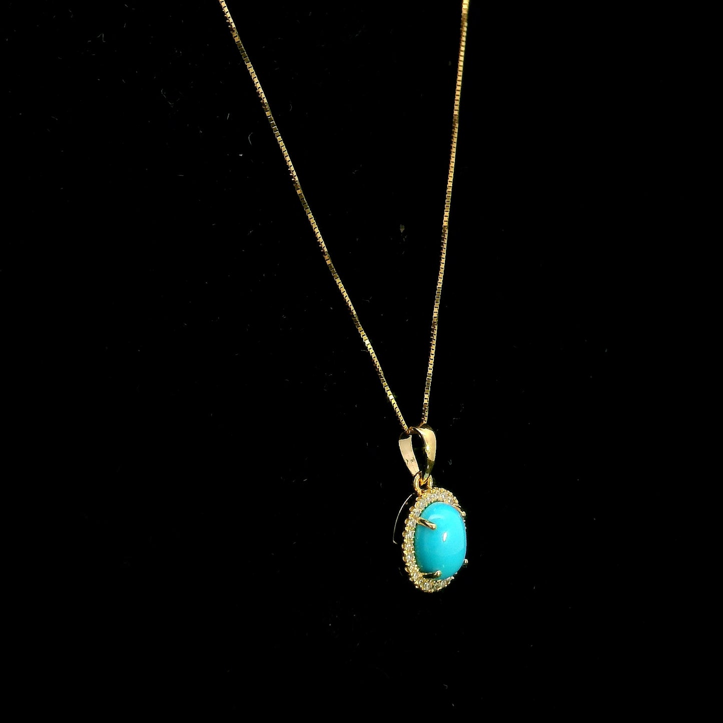 Natural turquoise diamond halo pendant in solid 18K yellow gold featuring a 1.22 carat oval turquoise surrounded by 0.12 carat natural diamonds.