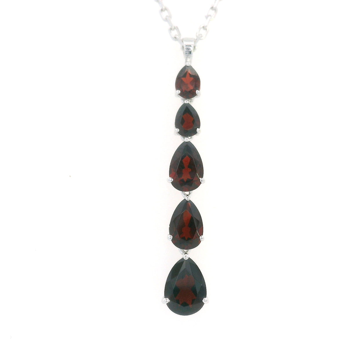 Pear shaped garnet drop pendant in 18K white gold featuring five graduated deep red garnets totalling 2.26 carat, arranged vertically in delicate prong settings. Chain sold separately