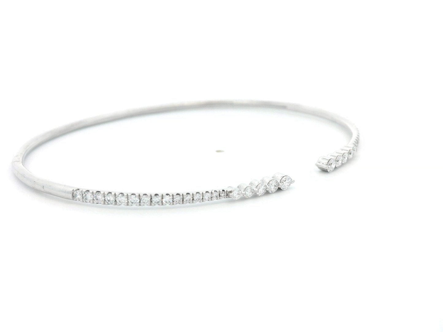 18K gold open diamond bangle bracelet with graduated diamonds, featuring a sleek and modern minimalist design.