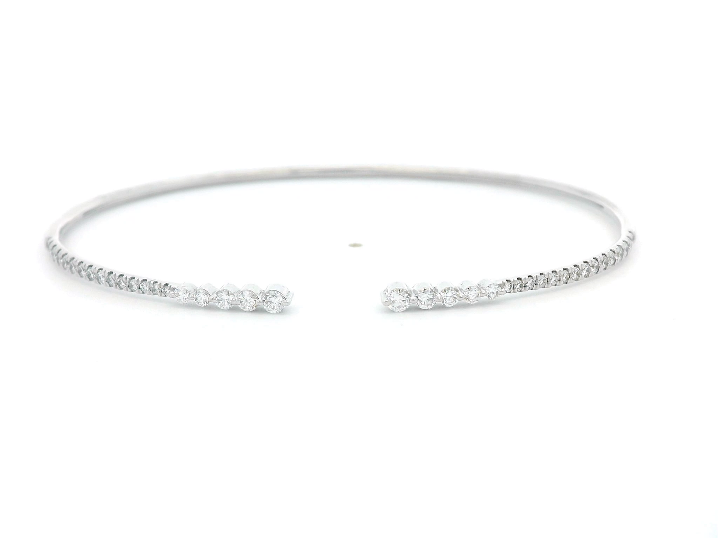 18K gold open diamond bangle bracelet with graduated diamonds, featuring a sleek and modern minimalist design.
