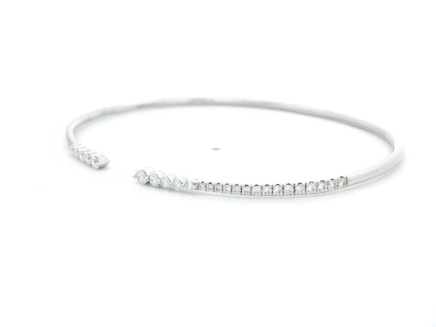 18K gold open diamond bangle bracelet with graduated diamonds, featuring a sleek and modern minimalist design.