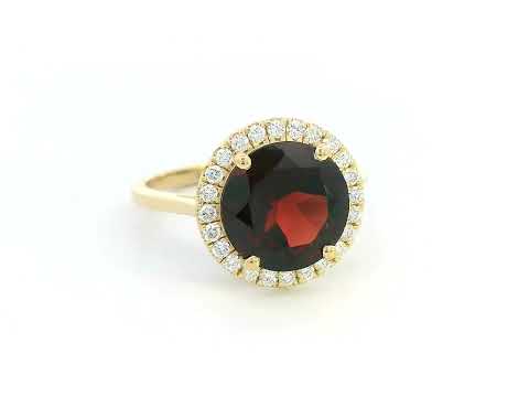 Round garnet and diamond halo ring in 18K yellow gold featuring a 3.85 carat garnet and 0.27 carats of diamonds.