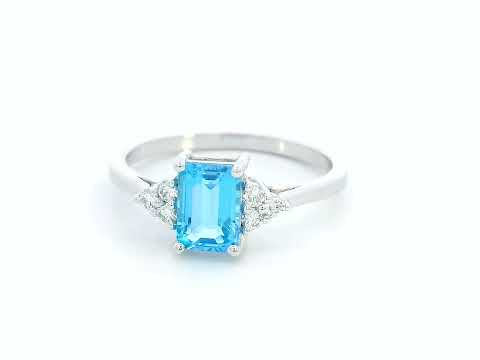 18K white gold ring with emerald-cut blue topaz and side diamond clusters – modern blue gemstone cocktail ring