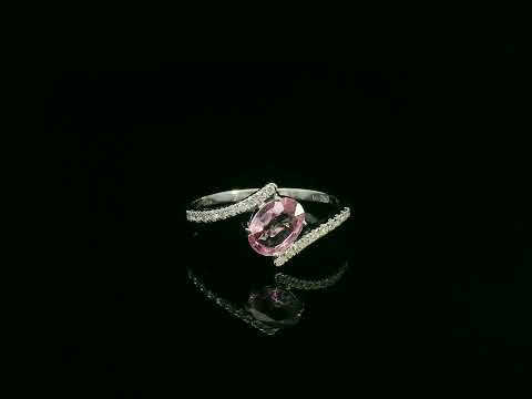 18K white gold bypass ring featuring an oval pink sapphire and pavé-set diamonds in a contemporary open design.