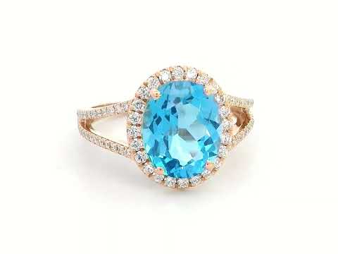 18K rose gold ring with a 4.54 carat oval Swiss Blue Topaz, diamond halo, and diamond-accented split shank design