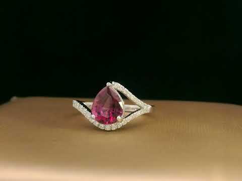 18K white gold rhodolite garnet and diamond wave ring featuring a 1.97ct pear-cut garnet framed by 0.23ct pavé diamonds in an elegant wave design.