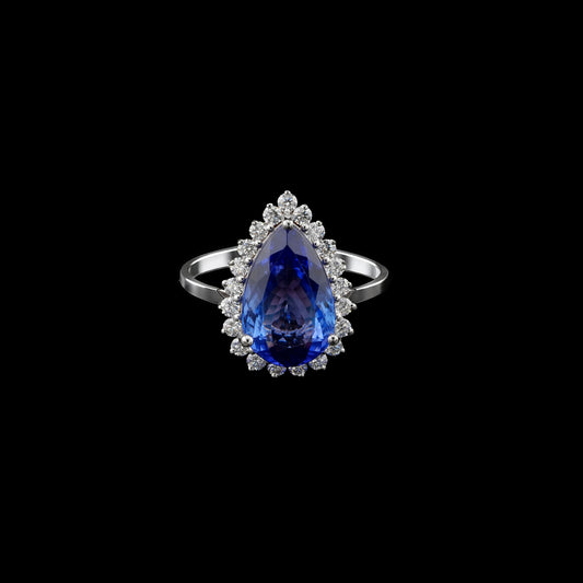18K white gold ring featuring a pear-shaped blue-violet tanzanite framed by an even halo of sparkling round diamonds.