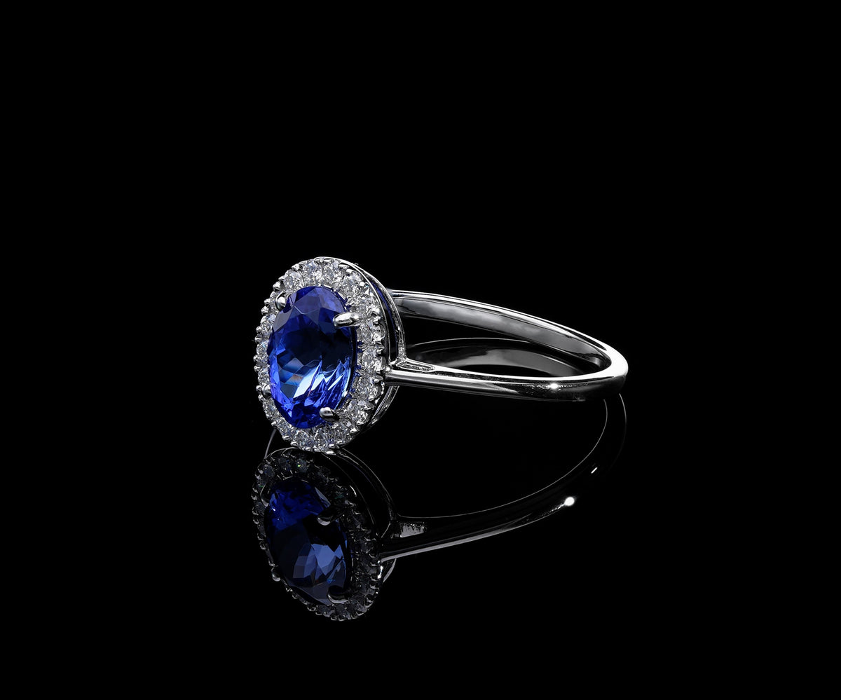 Tanzanite and diamond ring in 18K white gold with oval tanzanite and round diamond halo