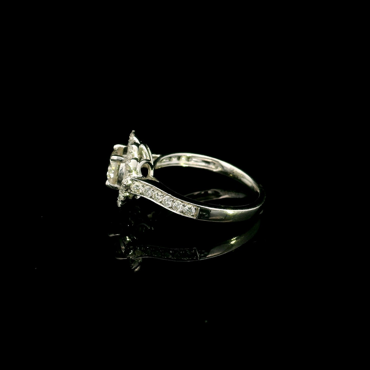 18K white gold diamond halo engagement ring featuring a 1 Carat round brilliant centre diamond with 0.79 Carat natural diamond halo and shoulders.