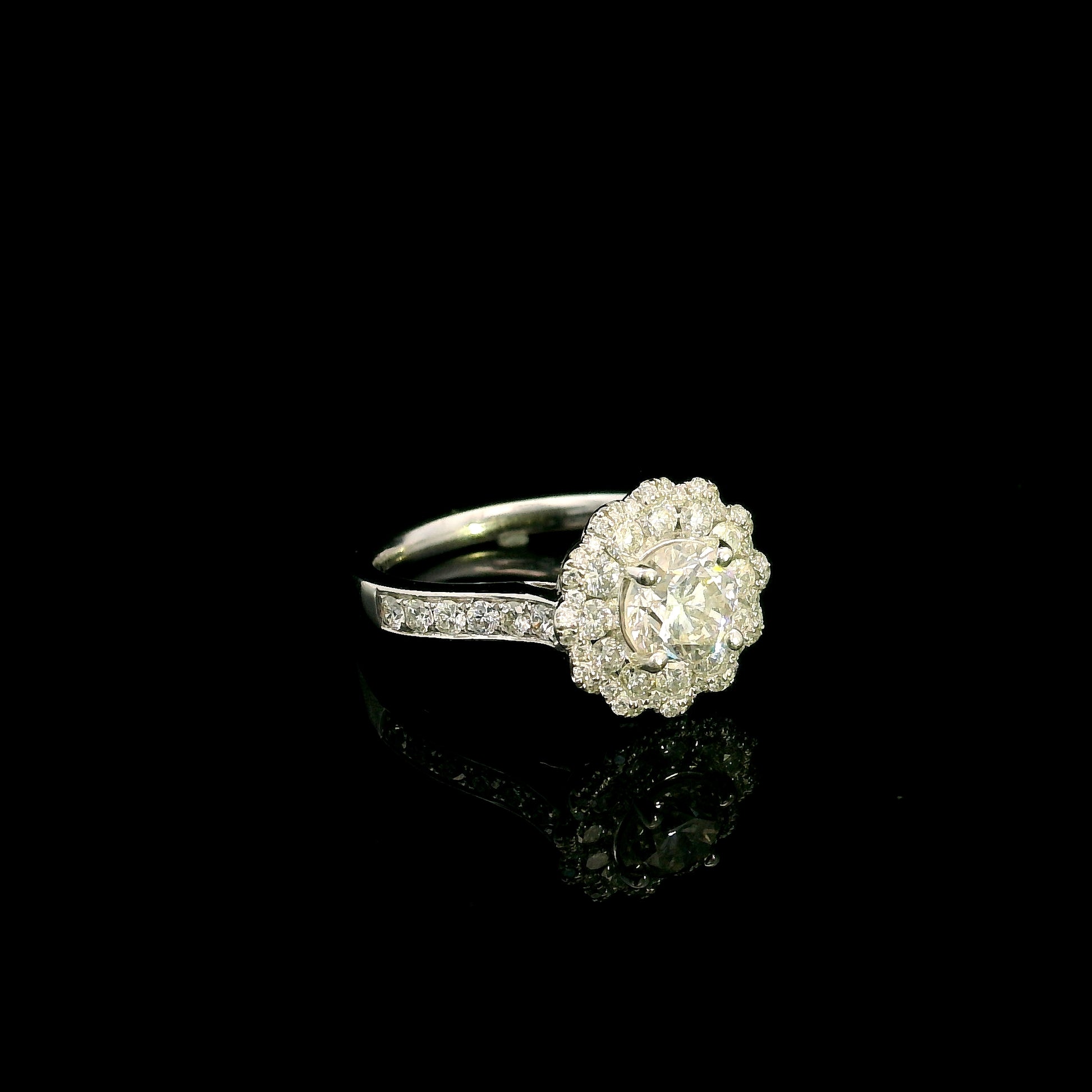 18K white gold diamond halo engagement ring featuring a 1 Carat round brilliant centre diamond with 0.79 Carat natural diamond halo and shoulders.
