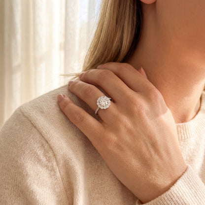 18K white gold halo diamond engagement ring featuring a 1.00 carat natural round brilliant diamond surrounded by a floral halo with pavé diamond band.