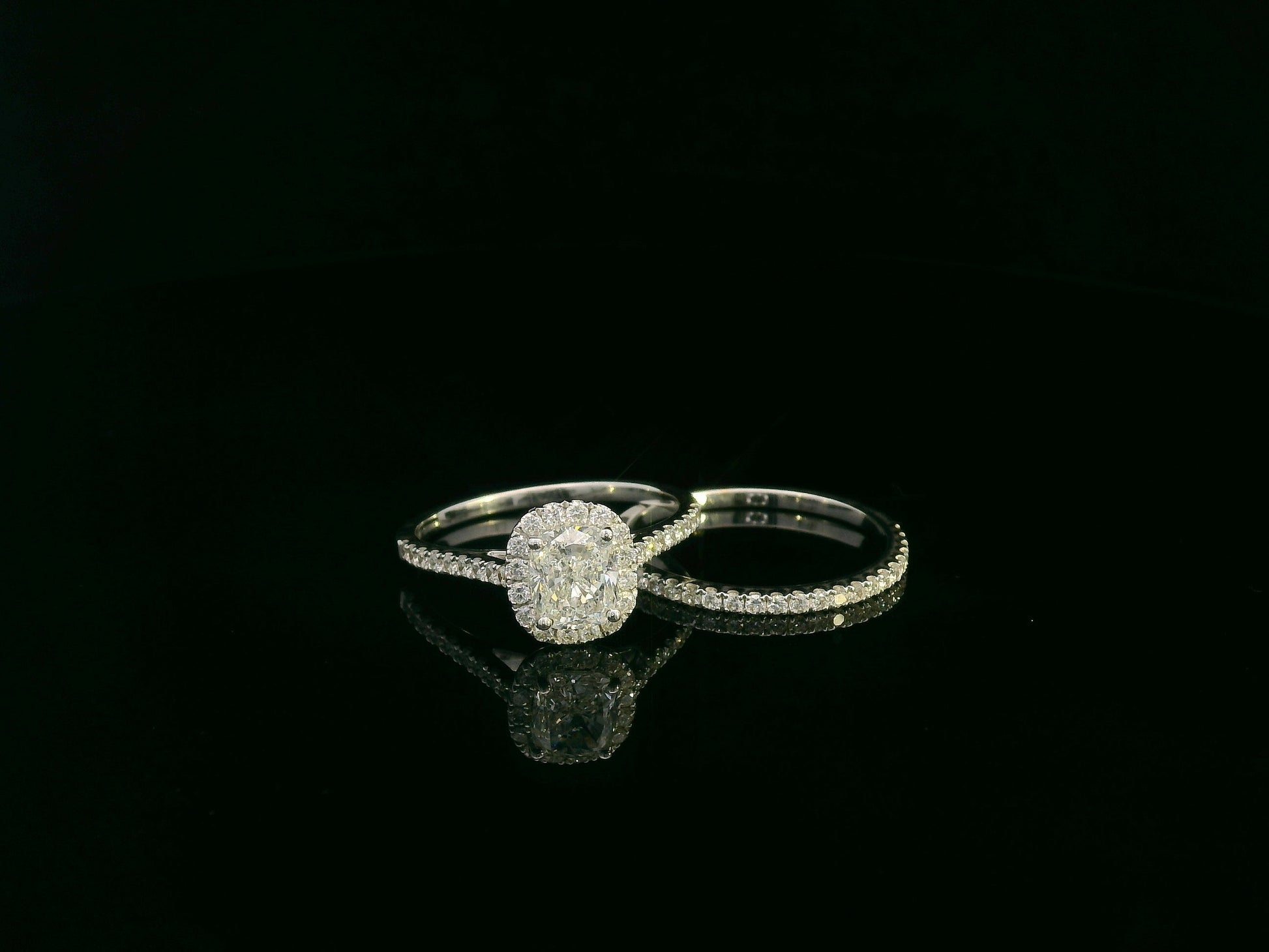 Cushion cut diamond bridal ring set in 18K white gold with diamond wedding band by Emirates Diamonds.