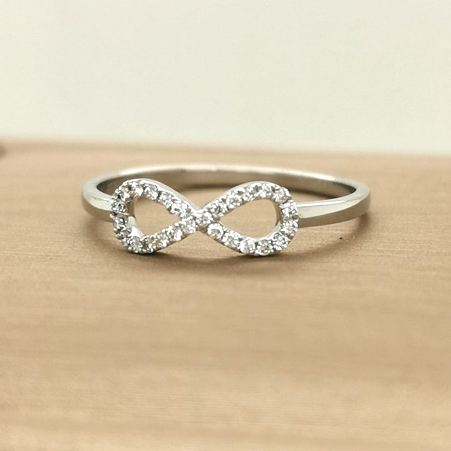 "Elevate your style with our exquisite infinity-designed ring, a symbol of limitless beauty and timeless grace. The infinity motif, with its flowing curves, represents unending love and boundless possibilities. Embellished with carefully selected diamonds for the best sparkle. The intertwining design creates a mesmerizing visual, while the 18k gold and stones adds a touch of personalized luxury. 